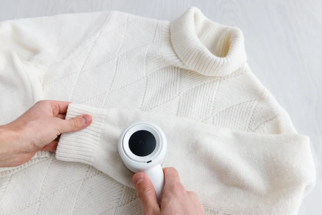 Une personne qui repasse un pull blanc