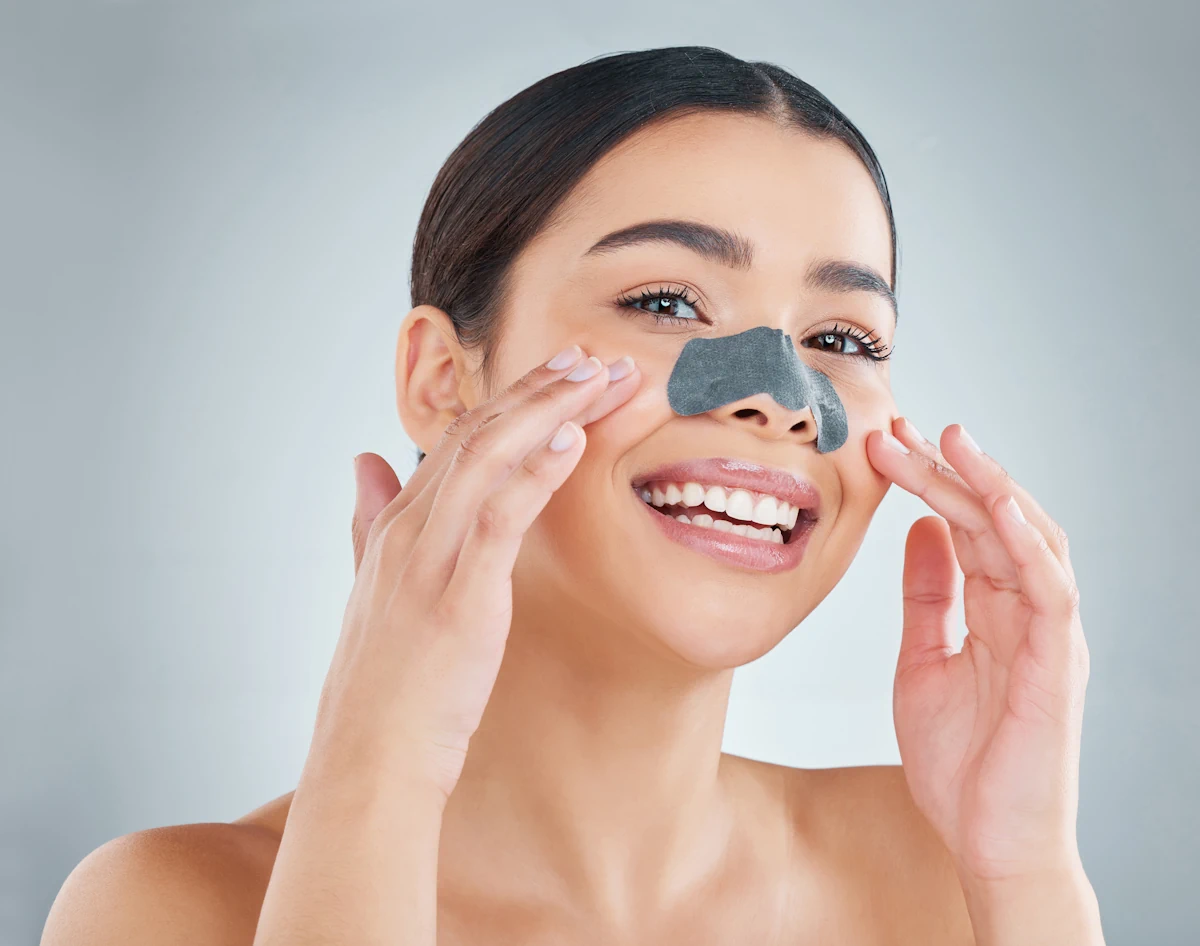 Une femme souriante qui met un patch sur le nez